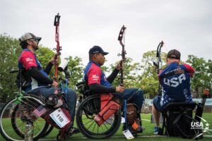 Three accomplished archery champions at the 2019 World Archery Para Championships. Archers observe an Outdoor Pro Shoot Down event while waiting their turn to compete.