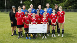 Courtesy Genesis Gives A photo of a youth spots team and coaches with representatives from Genesis Gives.