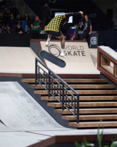 A skateboarder completes a nollie heel back flip. 