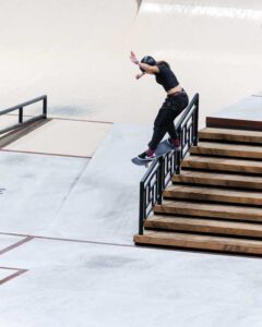 A skateboarder performs a front freeble rail