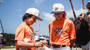 Two baseball players smile as they prepare for their game. 