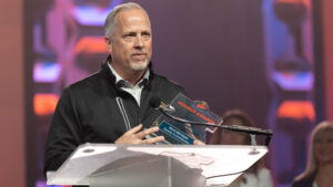 Mike Guswiler of West Michigan Sports Commission holds an award the organization received from Sports ETA. 