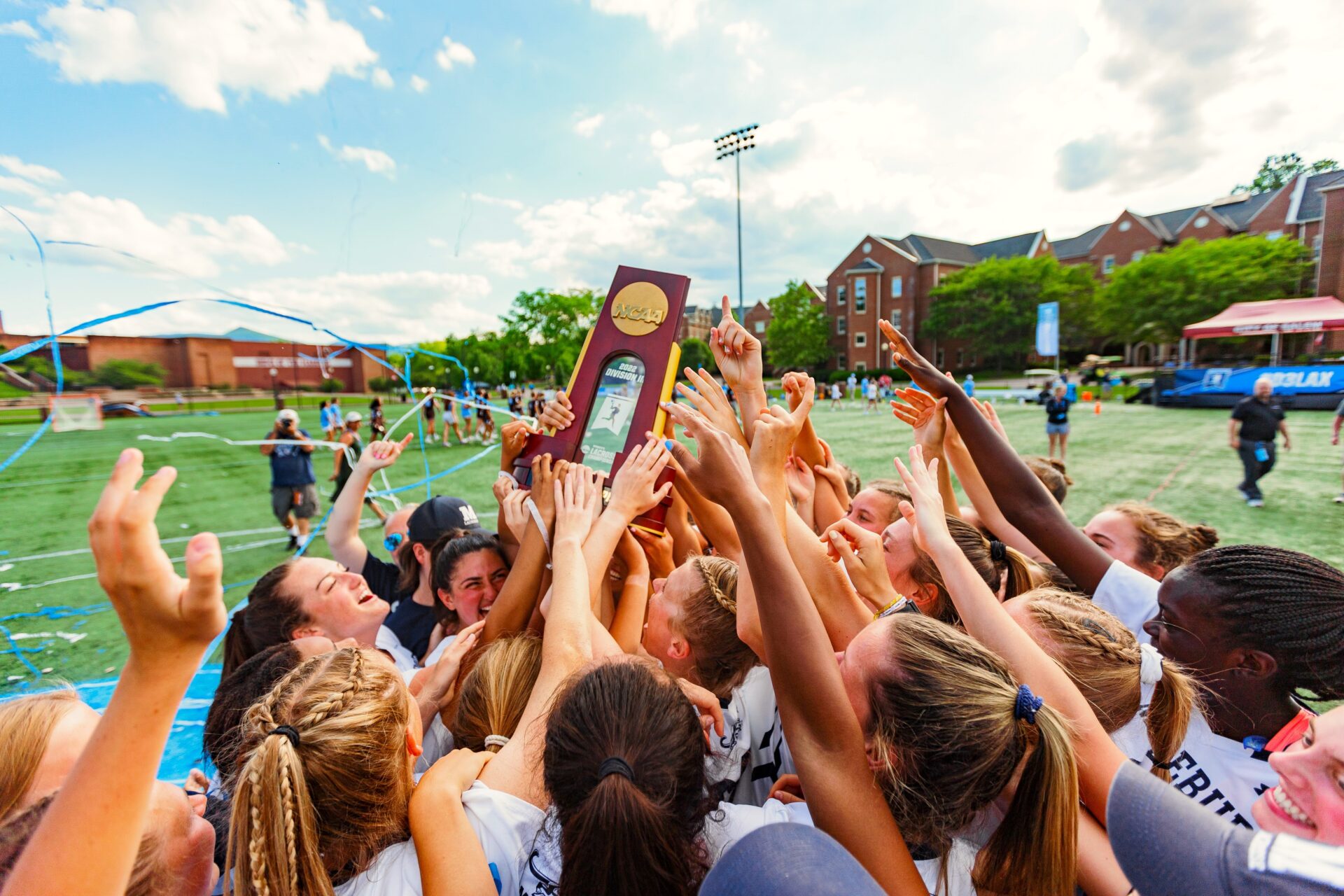 A women's volleyball team celebrating the trophy.