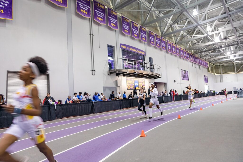 An action photo of runners on an indoor track