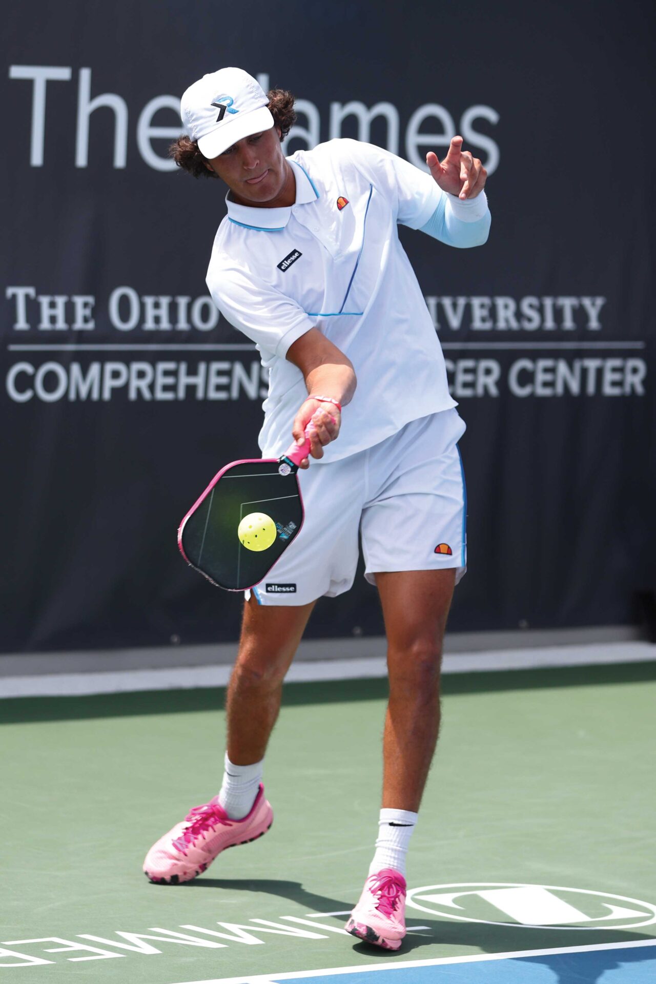 A player hitting the ball with a racket in pickleball.