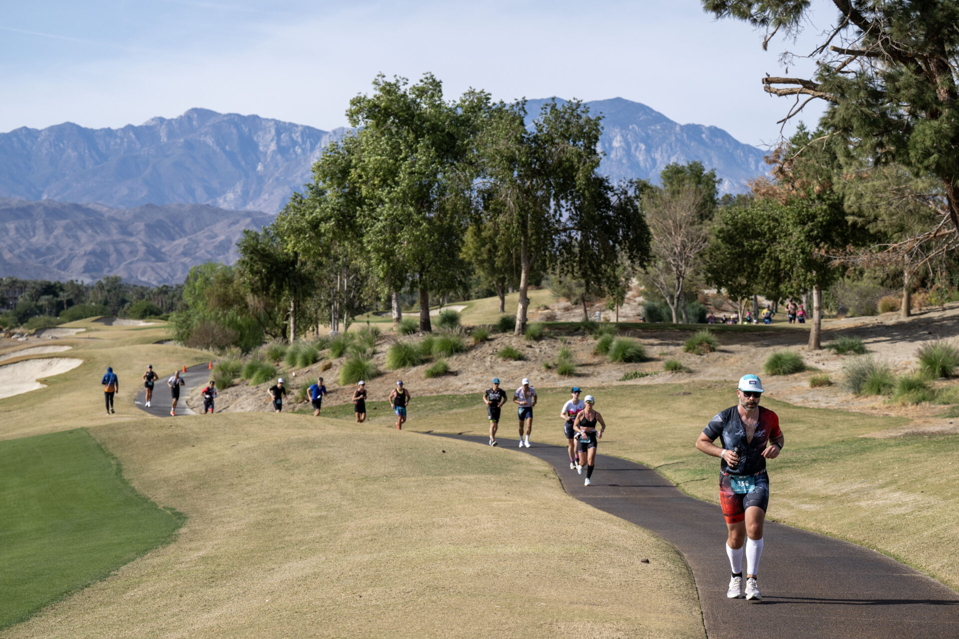 A group of triathletes run on the Indian Wells Golf Course during the 2024 IRONMAN 70.3 Indian Wells