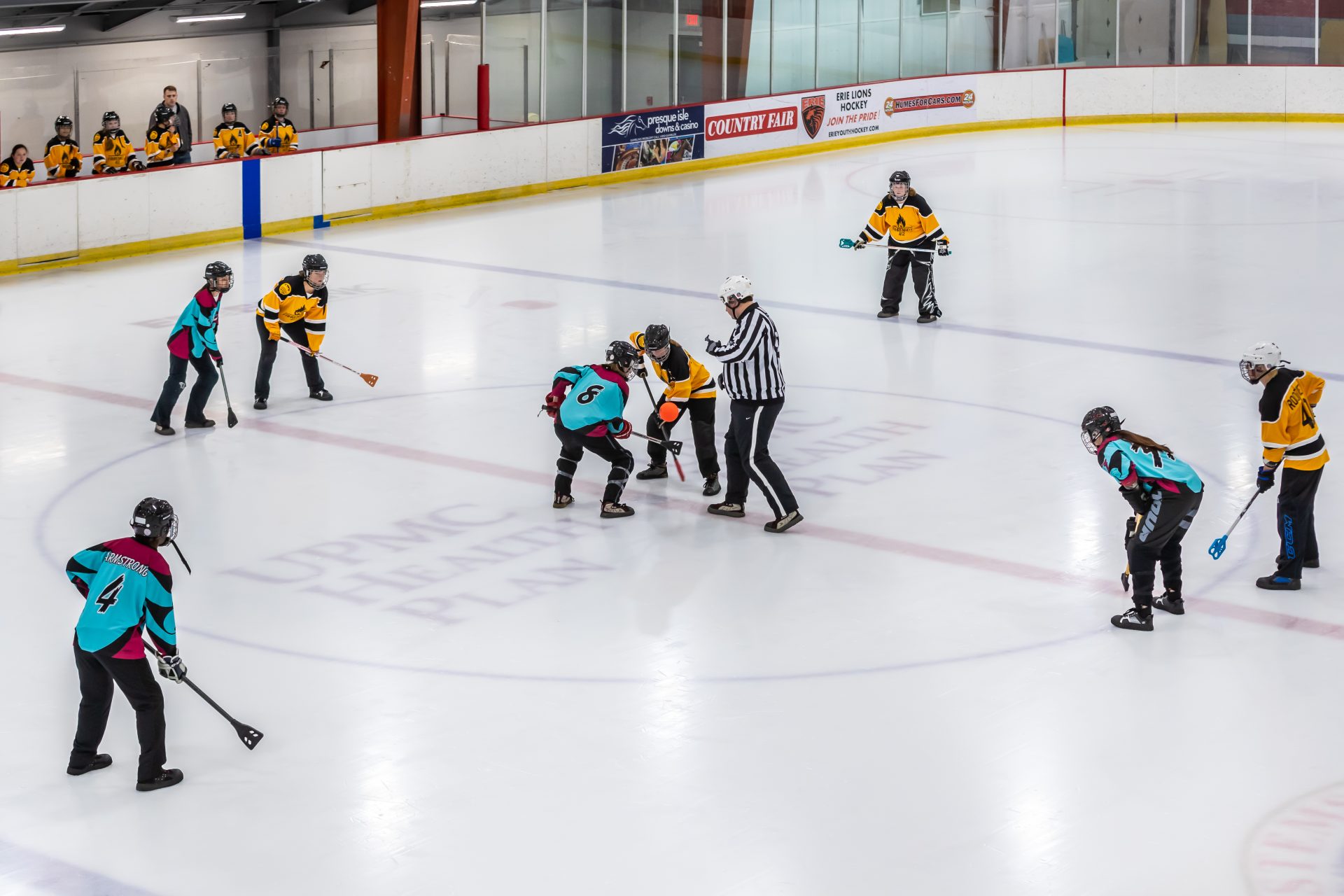 Teams playing broomball on an ice rink.
