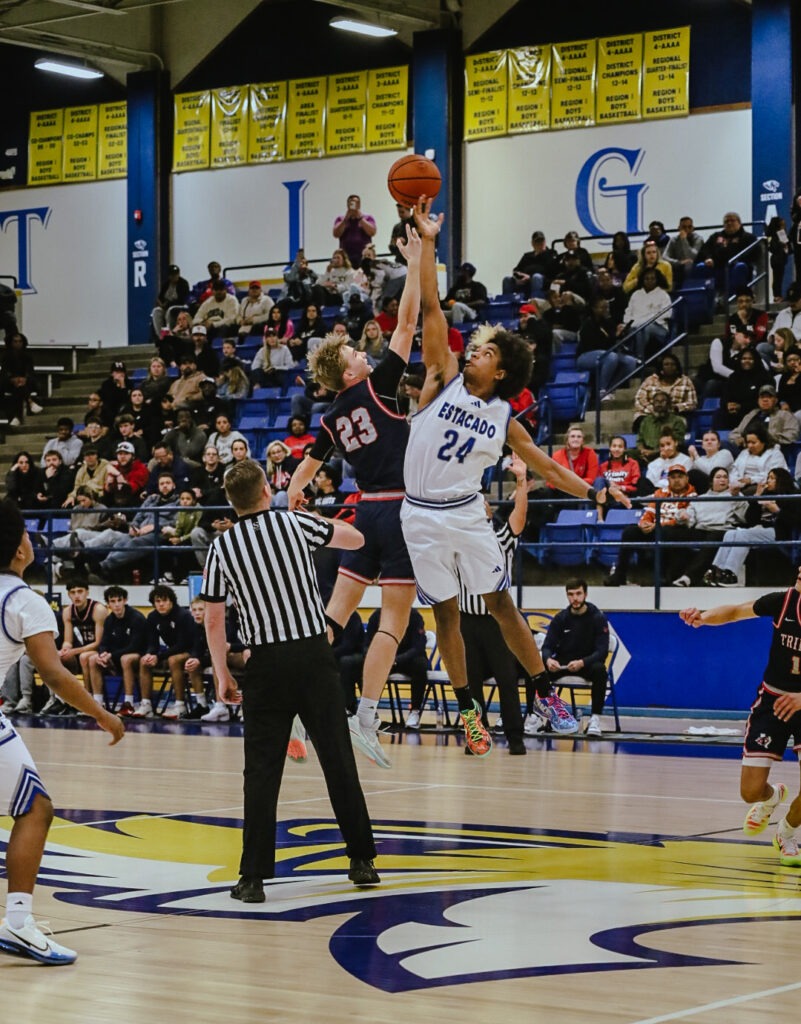 Two basketball jump for the ball during a tip off.